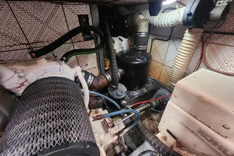 Slide: The Image of Engine room of a 1988 Marine Trader 43 boat, showcasing mechanical components and hoses. - 28