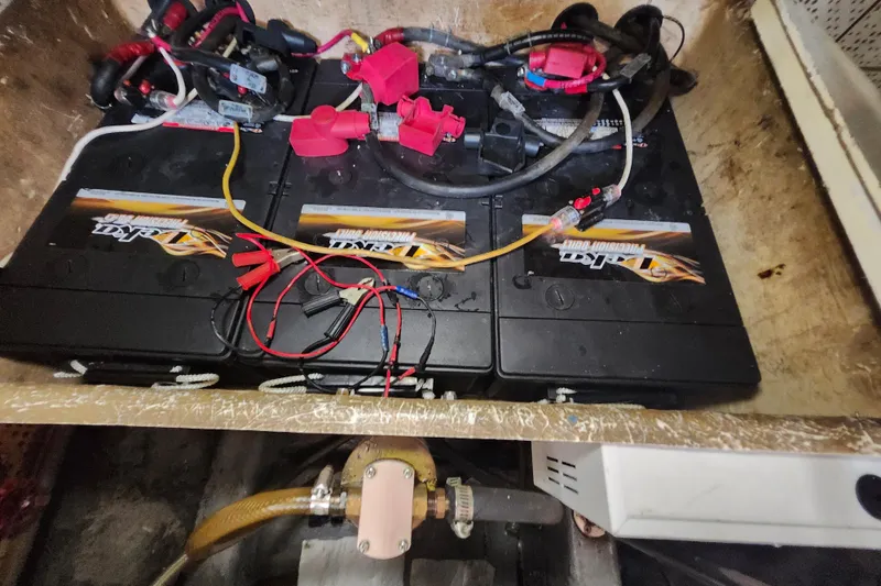 Slide: The Image of Marine Trader 43 (1988) battery compartment with multiple connected batteries and wiring. - 30
