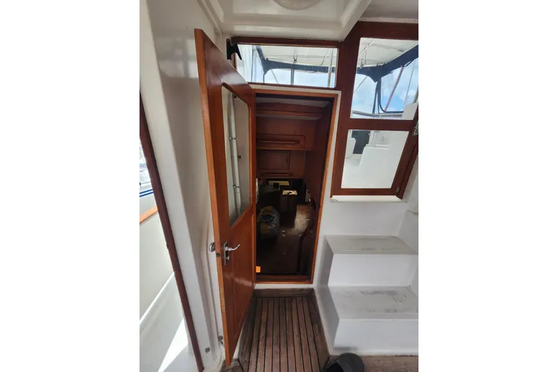 Slide: The Image of Interior view of 1988 Marine Trader 43 yacht with wooden door and steps. - 32