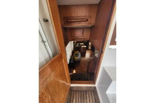 Slide: The Image of Interior view of 1988 Marine Trader 43 yacht, showcasing wooden cabinetry and cozy living space. - 33