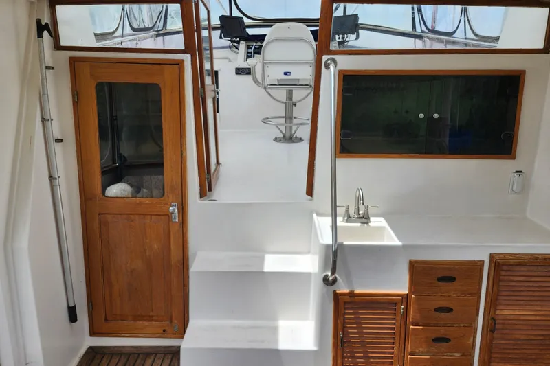 Slide: The Image of 1988 Marine Trader 43 interior with wooden door, steps, and sink area. - 34