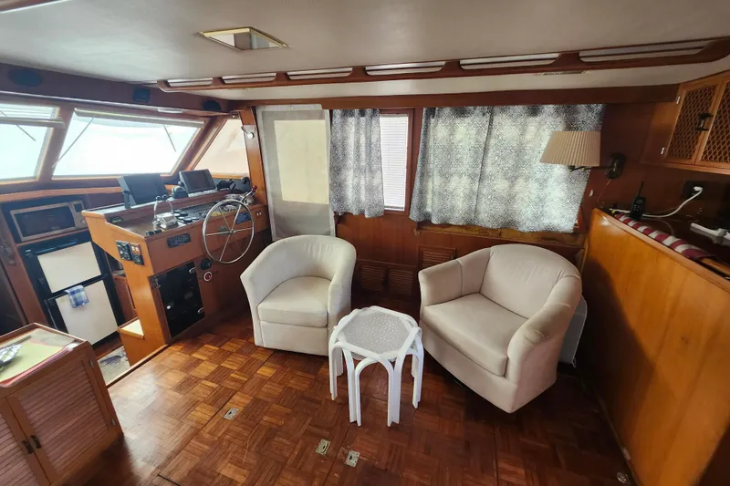Slide: The Image of Interior of 1988 Marine Trader 43 yacht with helm, seating, and wooden decor. - 4
