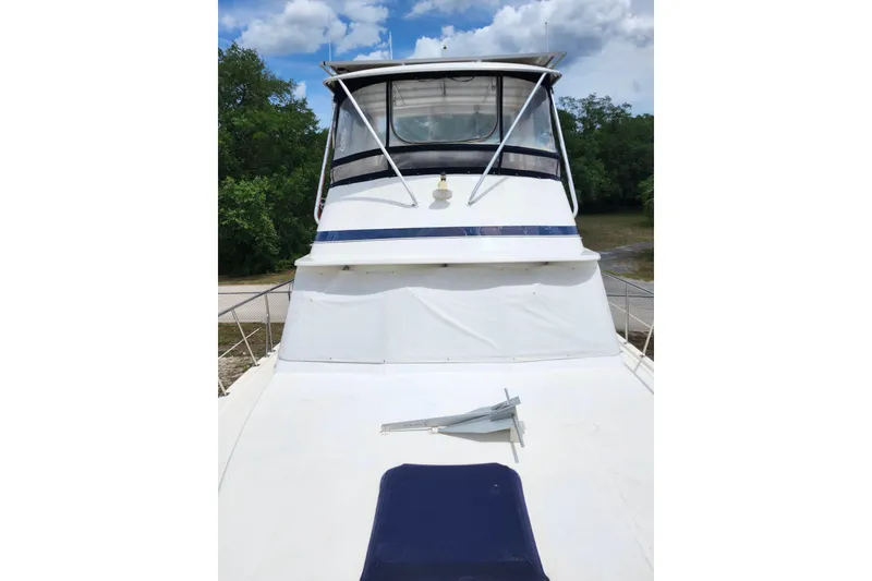 Slide: The Image of 1988 Marine Trader 43 yacht with white deck and blue accents, anchored outdoors. - 40