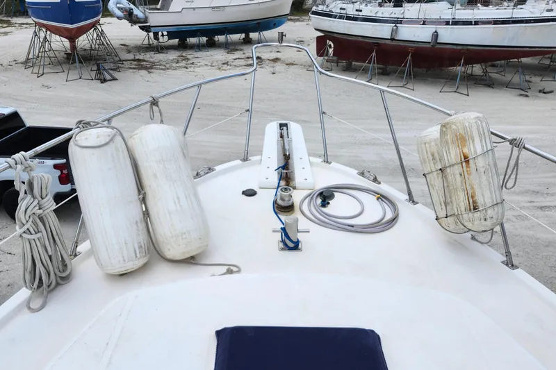 Slide: The Image of 1988 Marine Trader 43 boat deck with fenders and ropes, surrounded by other boats on stands. - 41