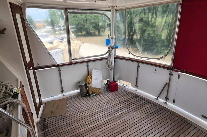 Slide: The Image of Enclosed deck area of 1988 Marine Trader 43 with wooden flooring and nautical equipment. - 42