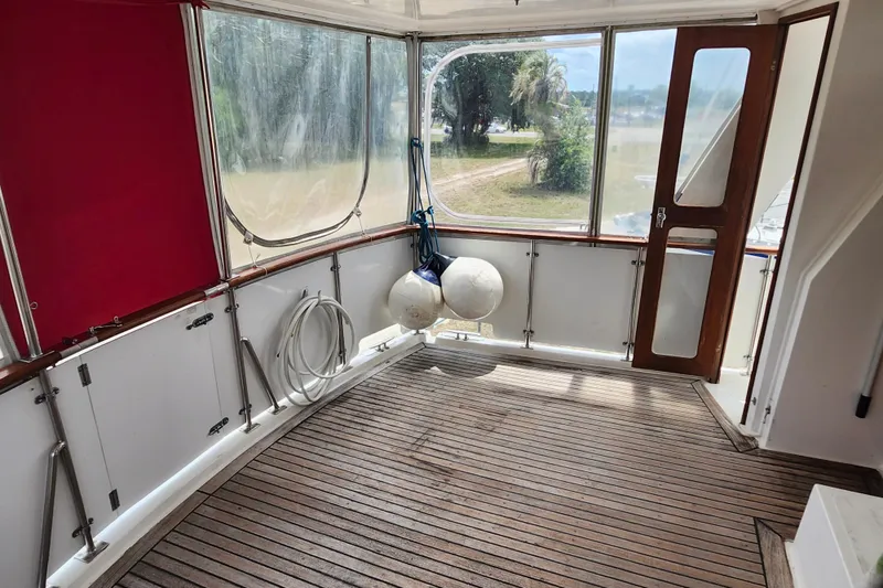 Slide: The Image of 1988 Marine Trader 43 interior with wooden flooring and large windows. - 43
