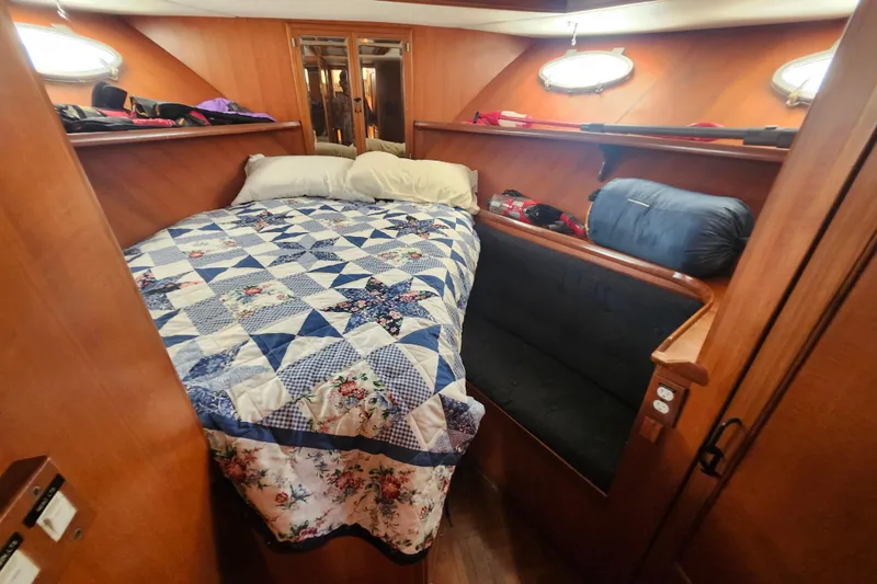 Slide: The Image of Cozy cabin interior of 1988 Marine Trader 43 with quilted bedspread and wooden paneling. - 7