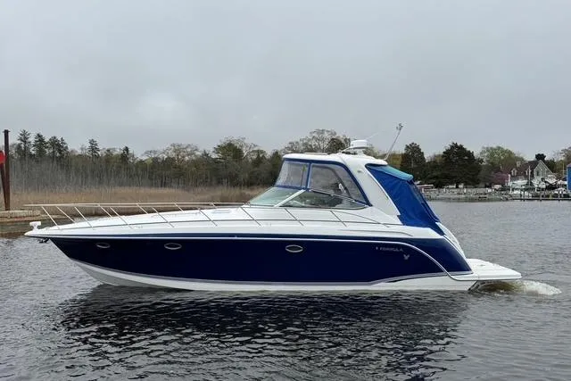 The Image of 2006 Formula 40 Performance Cruiser on calm water, featuring sleek blue and white design. - 0