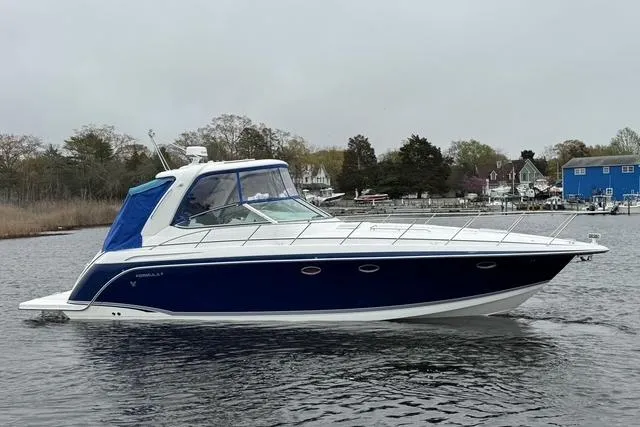 Slide: The Image of 2006 Formula 40 Performance Cruiser on calm water, featuring sleek blue and white design. - 6