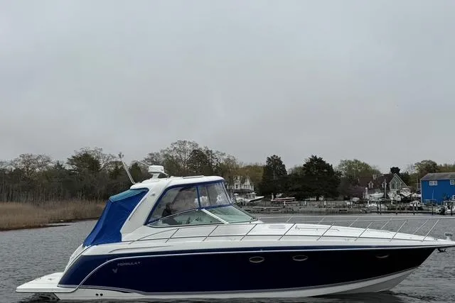 Slide: The Image of 2006 Formula 40 Performance Cruiser on calm water, featuring sleek blue and white design. - 8