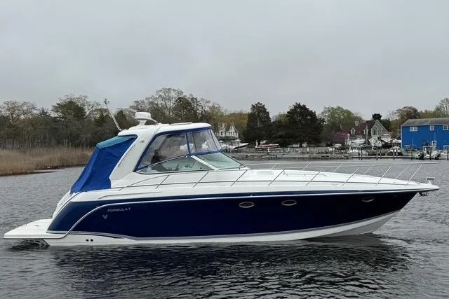 Slide: The Image of 2006 Formula 40 Performance Cruiser on calm water, featuring sleek blue and white design. - 9