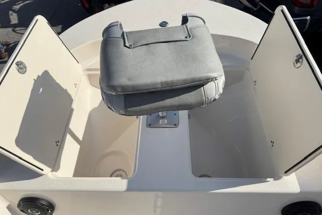 Slide: The Image of 2026 Carolina Skiff 192 JLS boat with open storage compartments and cushioned seat. - 11