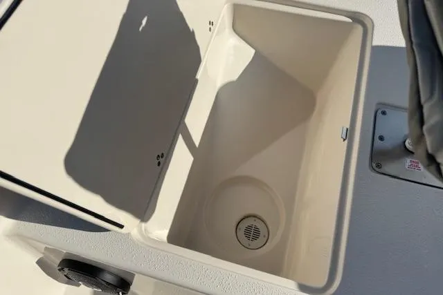 Slide: The Image of 2026 Carolina Skiff 192 JLS boat storage compartment with drain, open lid view. - 12