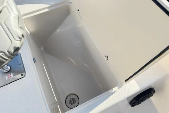 Slide: The Image of 2026 Carolina Skiff 192 JLS boat storage compartment with drain, open lid view. - 13