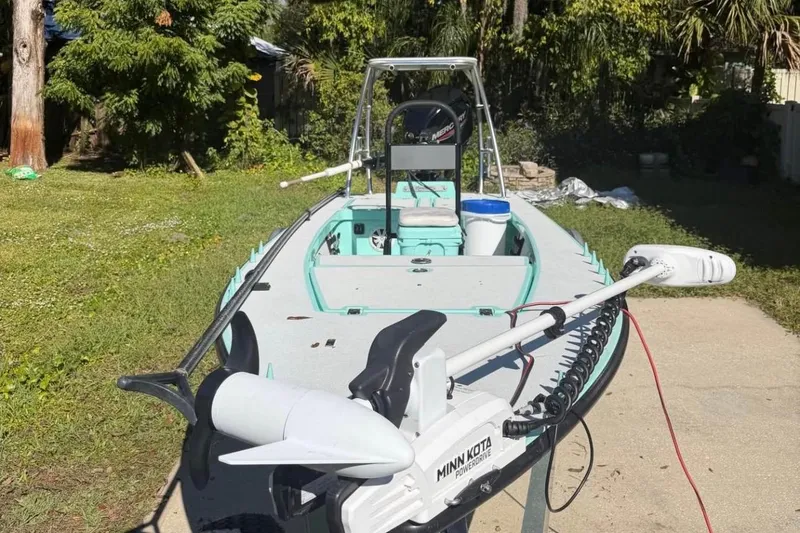 Slide: The Image of 2017 Cayo Boatworks 173 with Minn Kota trolling motor in a sunny backyard setting. - 6