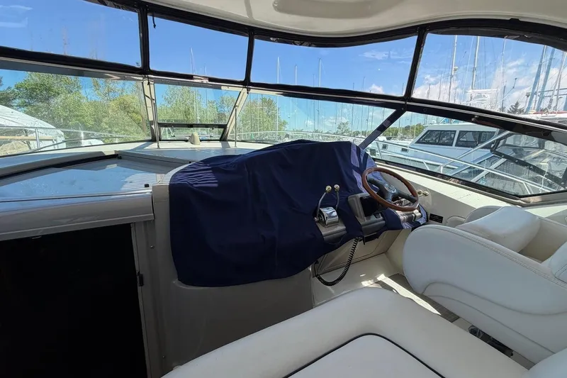 Slide: The Image of 2007 Sea Ray 380 Sundancer cockpit with covered helm and white seating. - 16