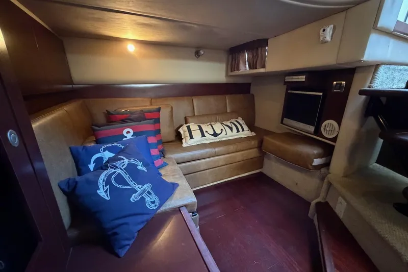 Slide: The Image of Interior of 2007 Sea Ray 380 Sundancer with cozy seating and nautical-themed pillows. - 19