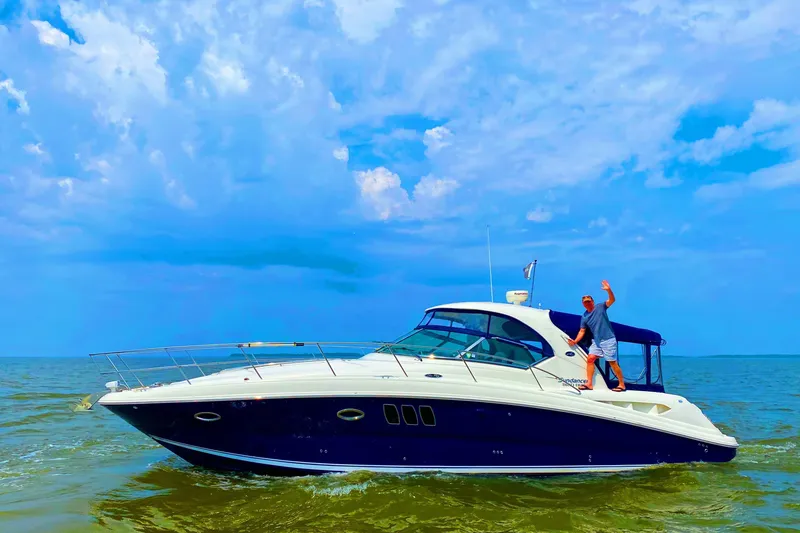Slide: The Image of 2007 Sea Ray 380 Sundancer cruising on open water under a vibrant blue sky. - 28