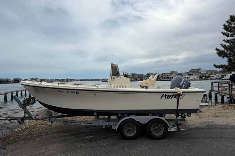 The Image of 2003 Parker 21SE Center Console boat on trailer by waterfront homes. - 0