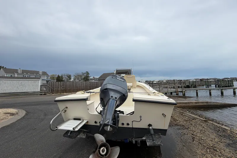 Slide: The Image of 2003 Parker 21SE Center Console boat with outboard motor near a dock. - 19