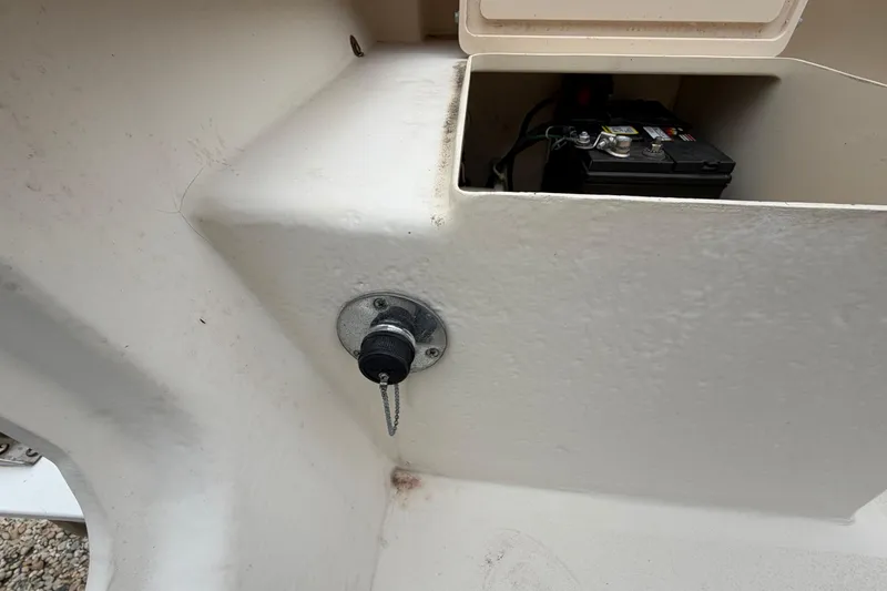 Slide: The Image of 2003 Parker 21SE Center Console boat battery compartment with visible battery and plug. - 23