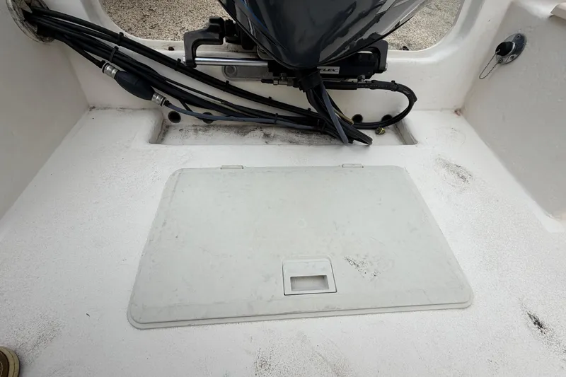 Slide: The Image of 2003 Parker 21SE Center Console boat deck with engine cables and storage hatch. - 24