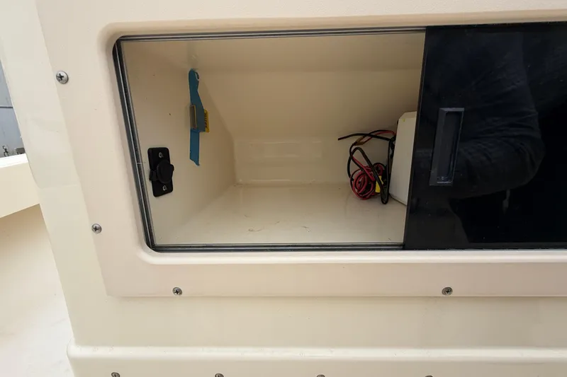 Slide: The Image of Open storage compartment on a 2003 Parker 21SE Center Console boat with visible wiring. - 35