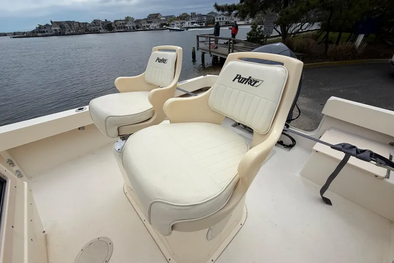 Slide: The Image of 2003 Parker 21SE Center Console boat with two cushioned seats by the water. - 37