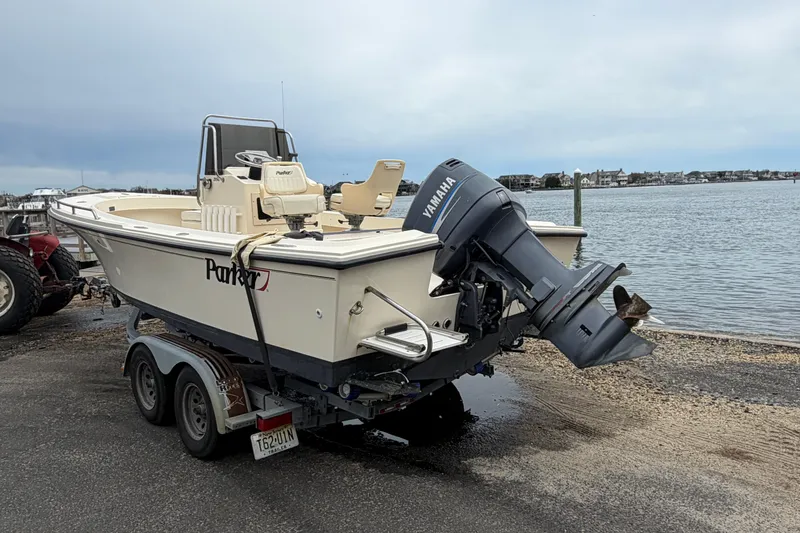 Slide: The Image of 2003 Parker 21SE Center Console boat on trailer by waterfront, featuring Yamaha outboard motor. - 4