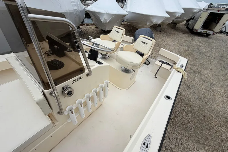 Slide: The Image of 2003 Parker 21SE Center Console boat with dual seats and rod holders, docked outdoors. - 41