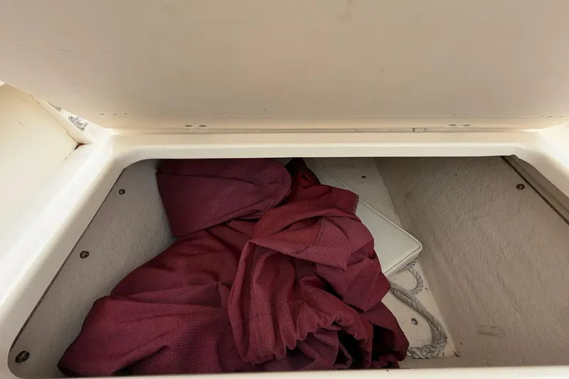 Slide: The Image of Storage compartment in a 2003 Parker 21SE Center Console boat with maroon fabric inside. - 45