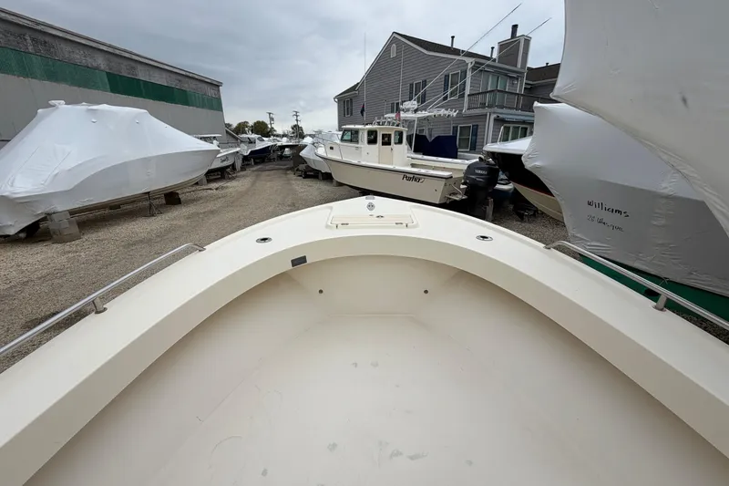 Slide: The Image of 2003 Parker 21SE Center Console boat in a marina storage area, surrounded by covered boats. - 53