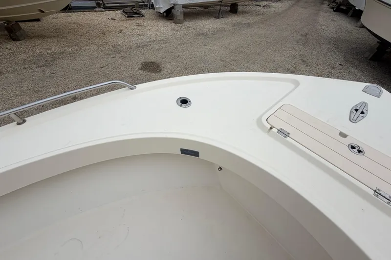 Slide: The Image of 2003 Parker 21SE Center Console boat deck, featuring clean white surface and storage compartments. - 54