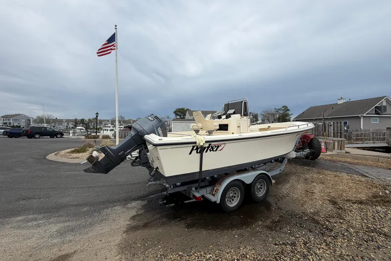 Slide: The Image of 2003 Parker 21SE Center Console boat on trailer near marina with American flag. - 6