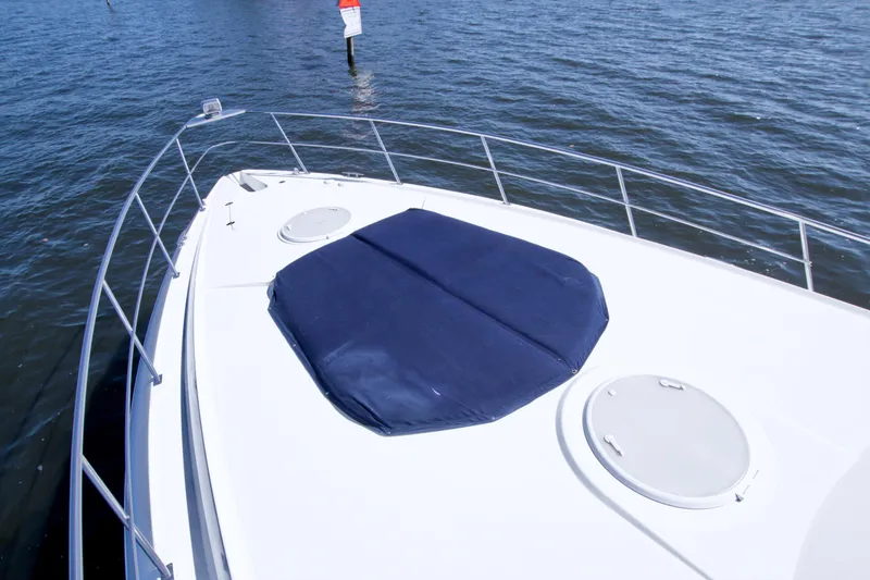 Slide: The Image of 2008 Cruisers Yachts 420 Express bow with blue sunpad on calm water. - 15