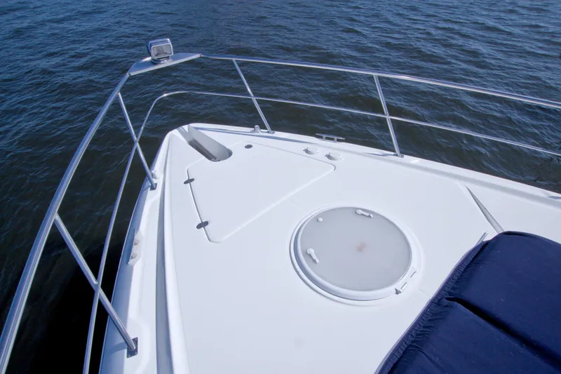Slide: The Image of Bow of 2008 Cruisers Yachts 420 Express on water, featuring deck hatch and railing. - 16