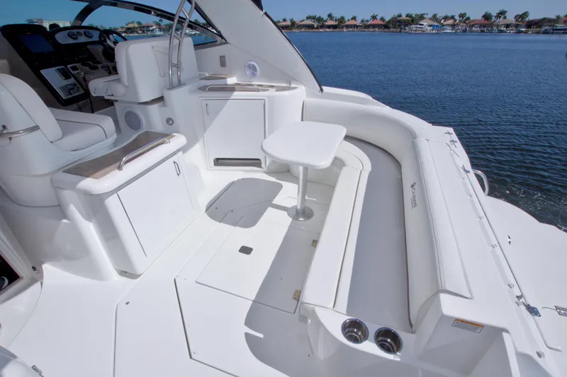 Slide: The Image of 2008 Cruisers Yachts 420 Express cockpit with white seating and table, overlooking serene water. - 23