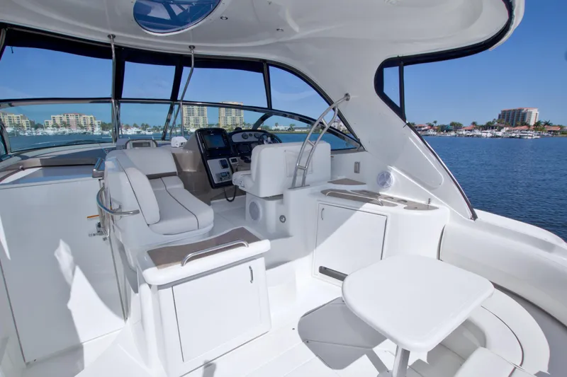 Slide: The Image of 2008 Cruisers Yachts 420 Express cockpit with luxurious seating and modern controls, overlooking marina. - 24