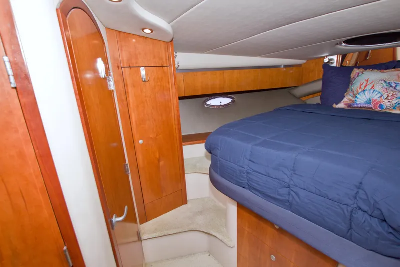 Slide: The Image of 2008 Cruisers Yachts 420 Express cabin with wooden cabinetry and cozy bedding. - 45