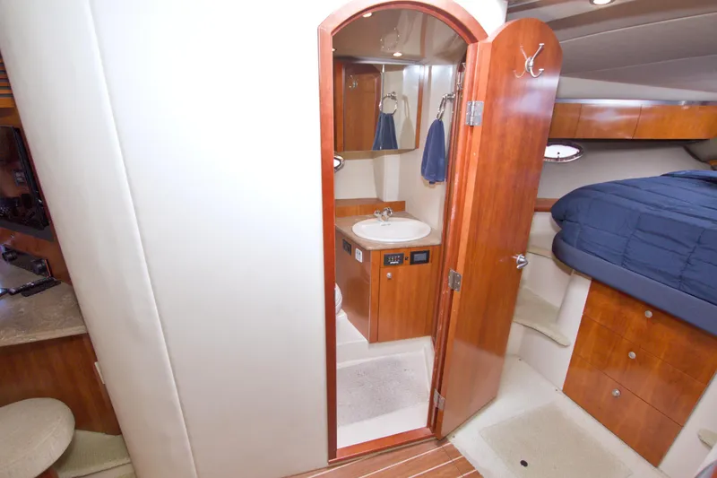 Slide: The Image of Interior of 2008 Cruisers Yachts 420 Express, featuring a cozy cabin with wood finishes. - 47