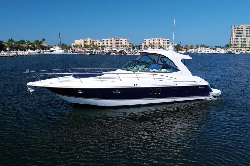 Slide: The Image of 2008 Cruisers Yachts 420 Express on calm water, with marina and buildings in background. - 75