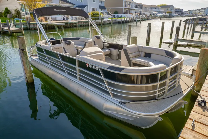 The Image of 2023 Berkshire 24 RFX LE 2.75 pontoon boat docked in a serene marina setting. - 1