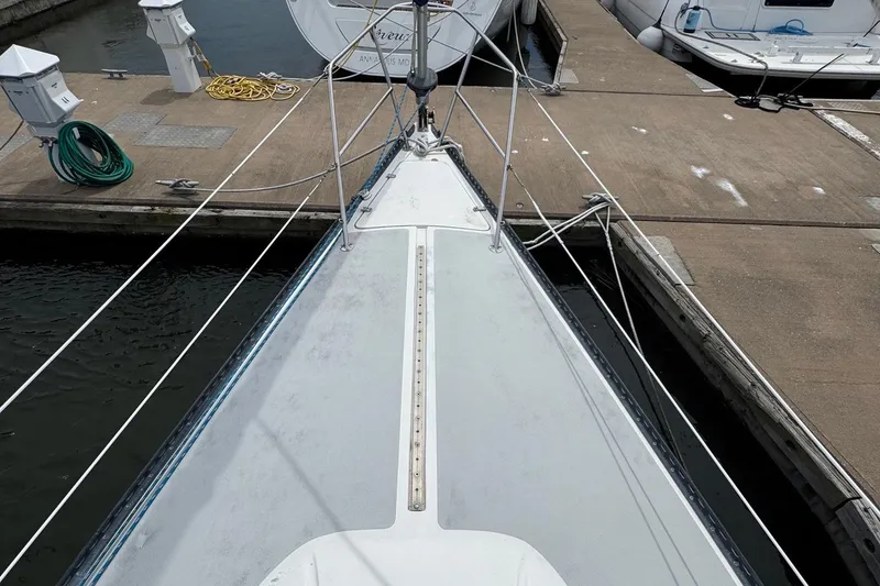 Slide: The Image of Bow view of a 1986 Catalina 38 sailboat docked at a marina. - 10