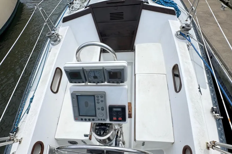 Slide: The Image of 1986 Catalina 38 sailboat cockpit with navigation instruments and steering wheel. - 12