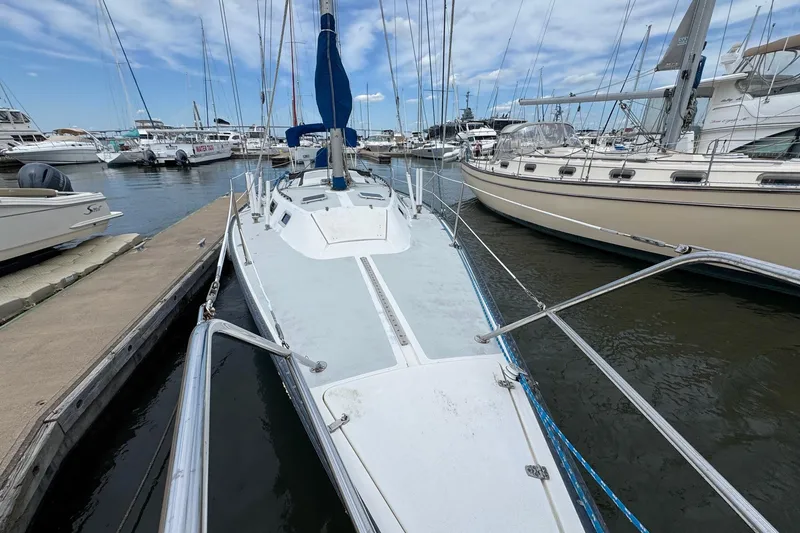 Slide: The Image of 1986 Catalina 38 sailboat docked at marina, surrounded by other boats. - 4
