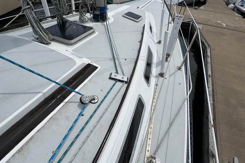 Slide: The Image of 1986 Catalina 38 sailboat deck with ropes and hatches at dockside. - 5
