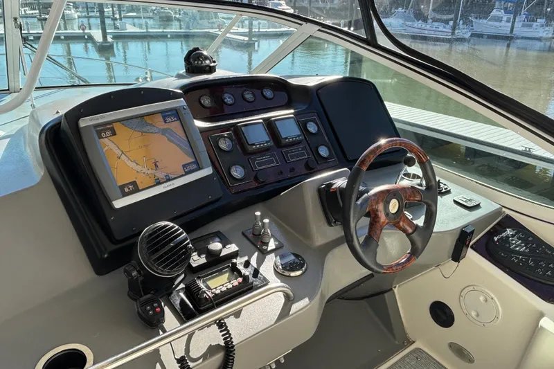 Slide: The Image of 2005 Cruisers Yachts 455 Express Motoryacht helm with navigation equipment and wooden steering wheel. - 12