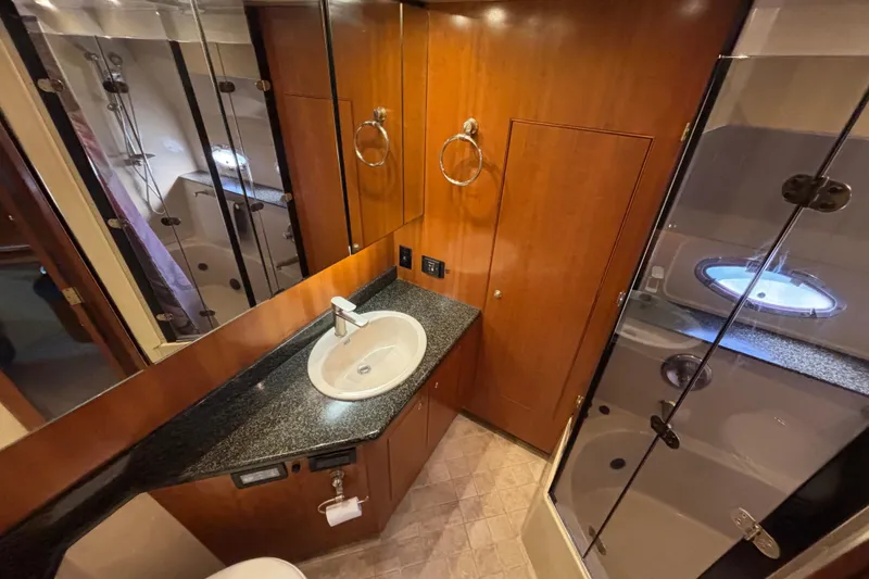 Slide: The Image of Luxurious Master bathroom in 2005 Cruisers Yachts 455 Express Motoryacht with Linen Closet, Vanity, medicine cabinets and access to tub/shower. - 26