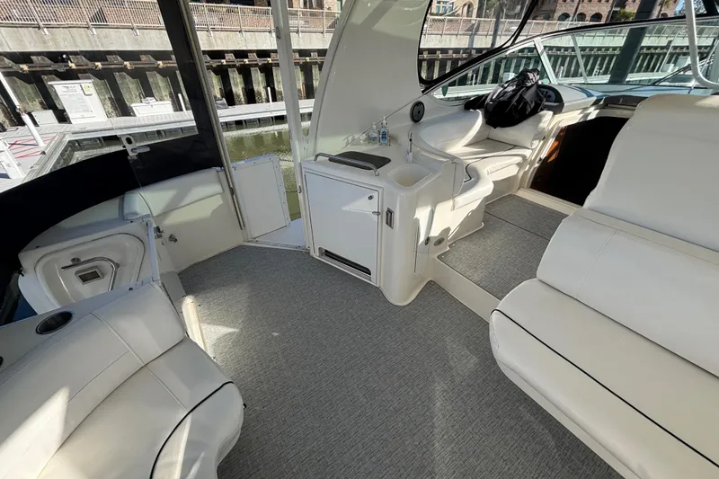 Slide: The Image of 2005 Cruisers Yachts 455 Express Motoryacht aft deck area with Wet Bar, Beverage Refrigerator, comfortable seating and new Grassmat snap-in flooring - 6