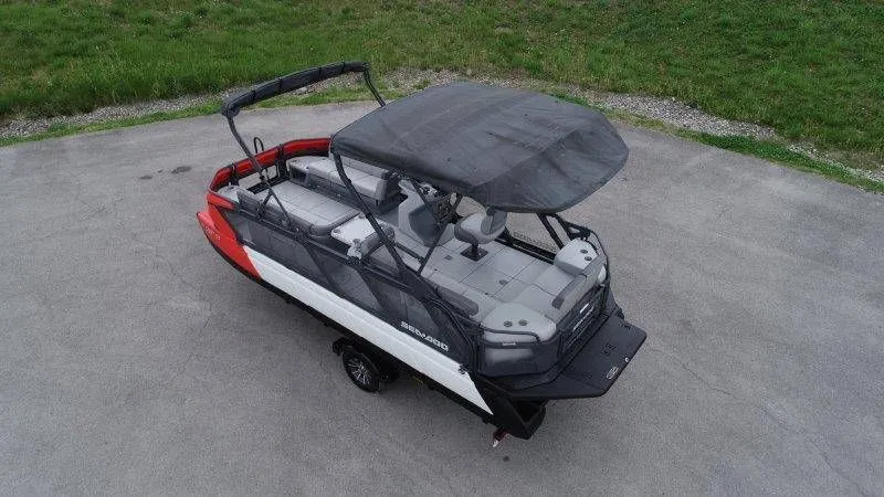 Slide: The Image of 2023 Sea-Doo Switch Cruise 21 pontoon boat with canopy on pavement. - 7
